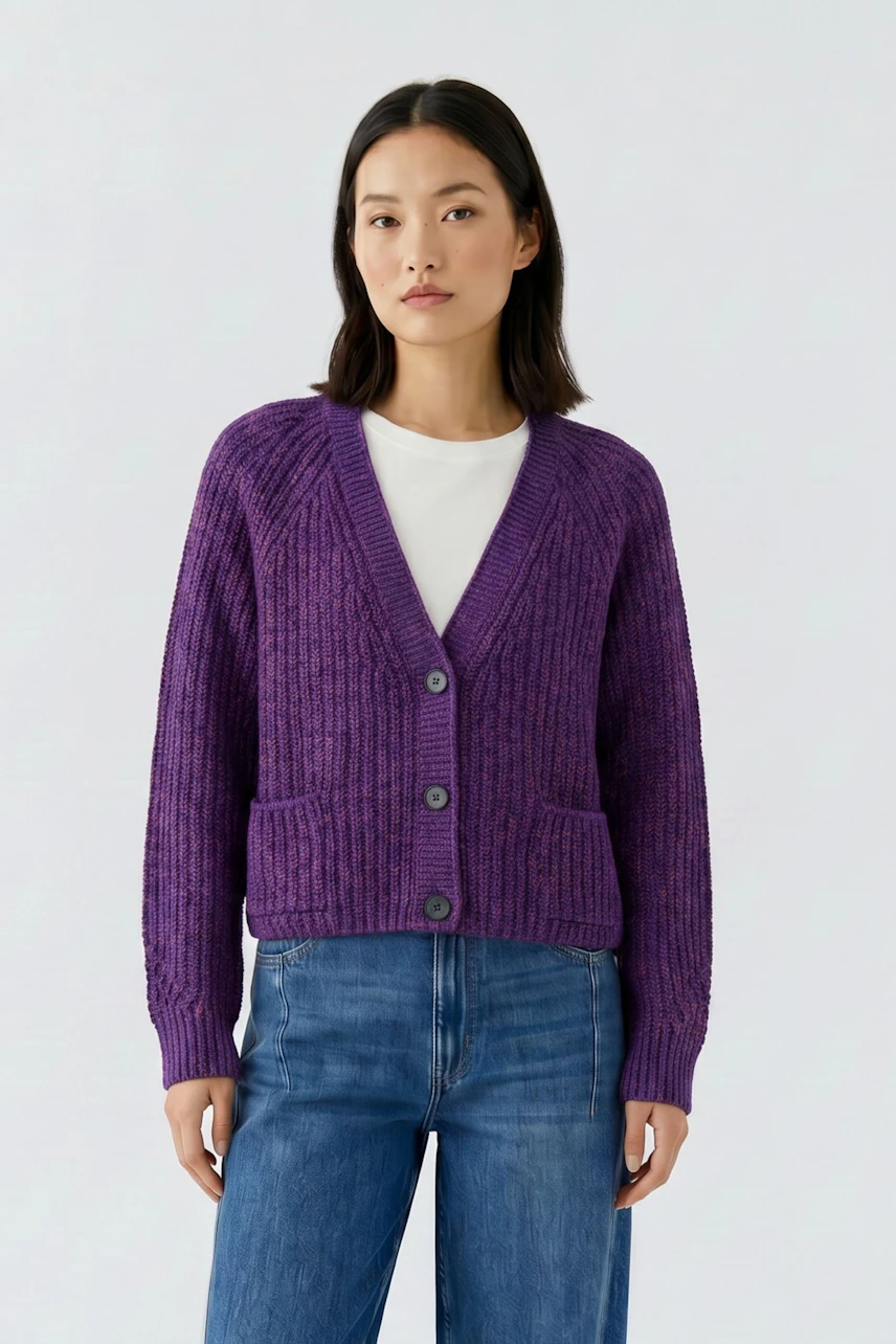 Casual women's cardigan: Woman in purple knit cardigan over white tee and jeans, standing confidently.