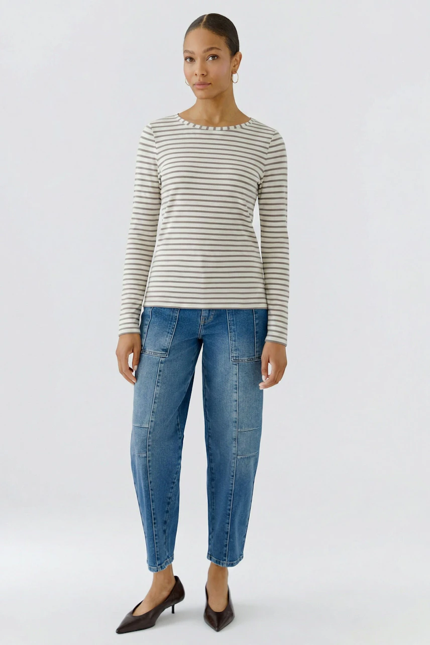 Gestreiftes Langarmshirt: Frau im lässigen Shirt und Jeans, steht selbstbewusst.