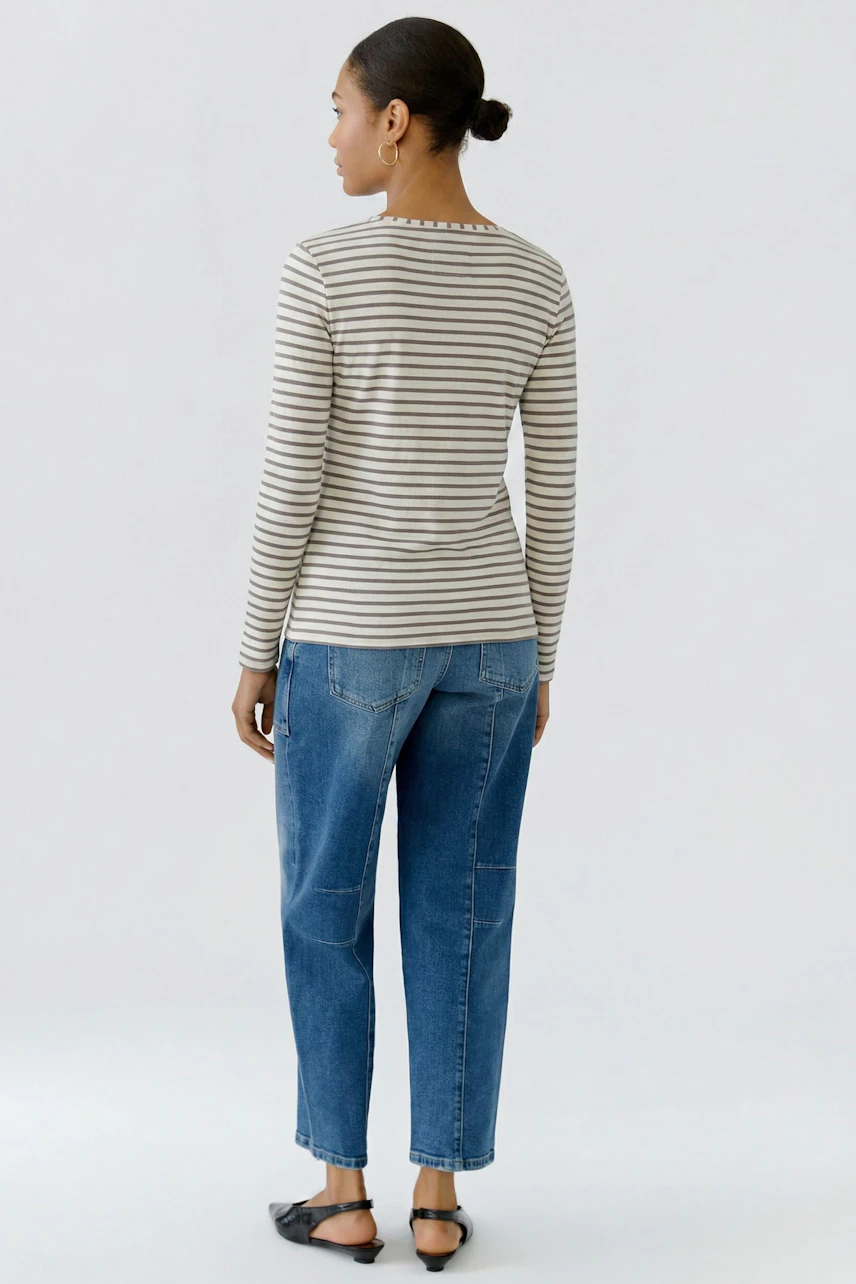 Frau im gestreiften Langarmshirt und Jeans, von hinten. Lässiger Look für den Alltag.