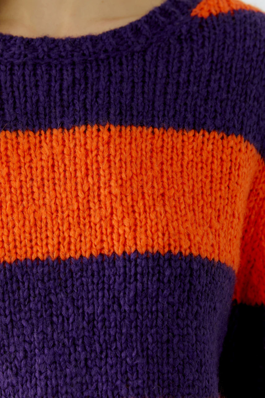 Colorful striped pullover: Close-up of orange and purple knit fabric, showcasing bold, vibrant design.