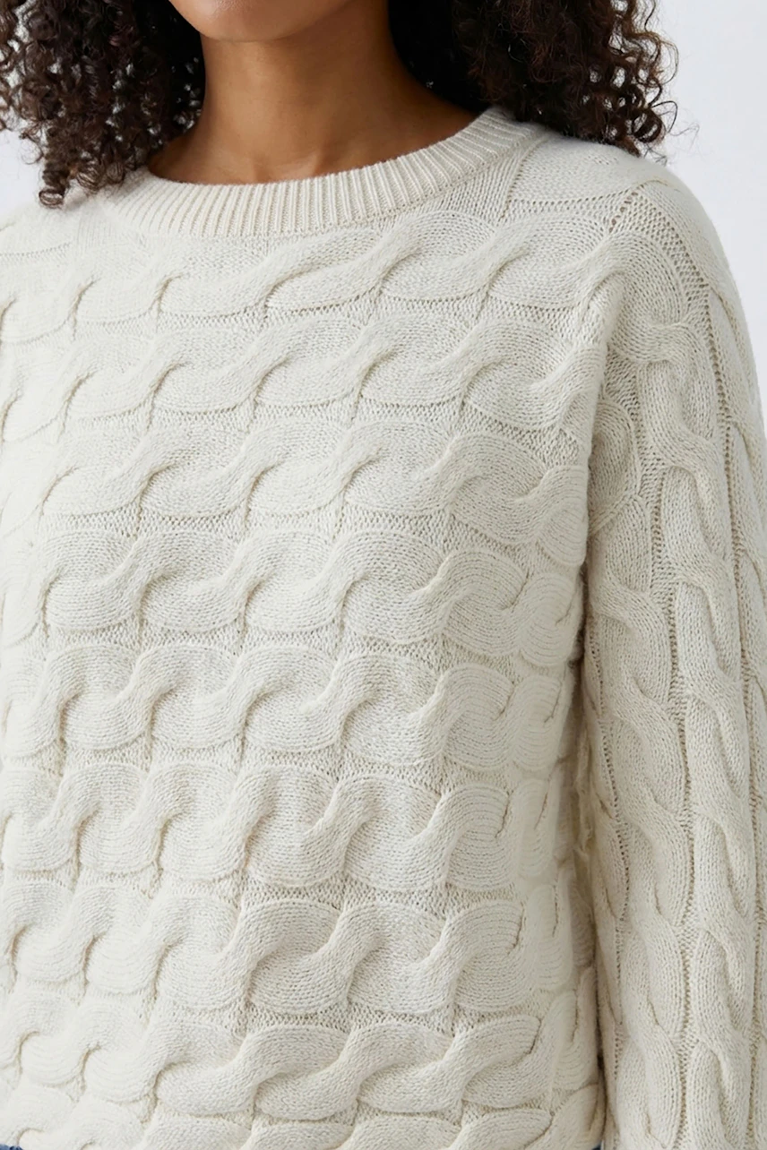 Casual women's pullover: Close-up of a light beige knitted pullover with a textured pattern.