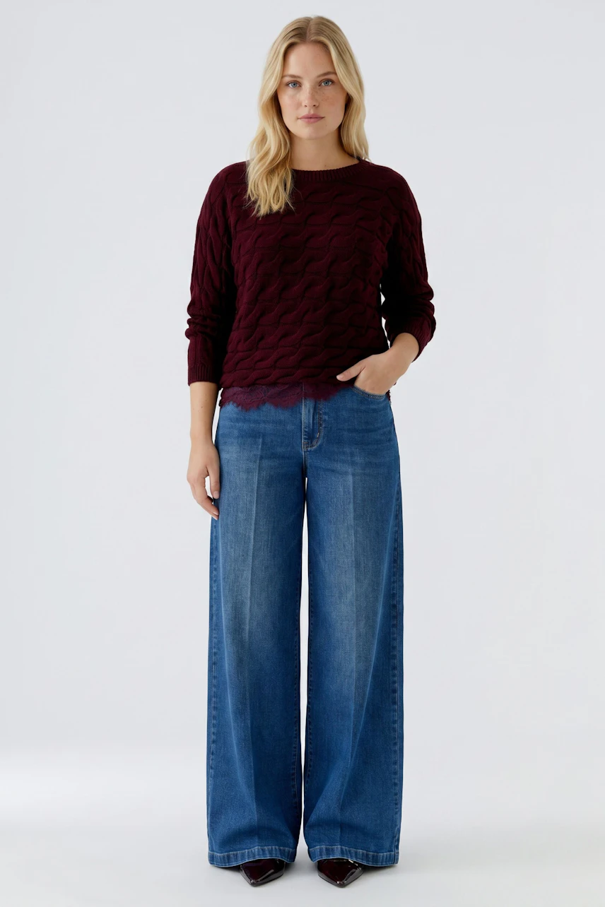 Casual women's pullover: A woman in a burgundy textured pullover paired with matching pants.