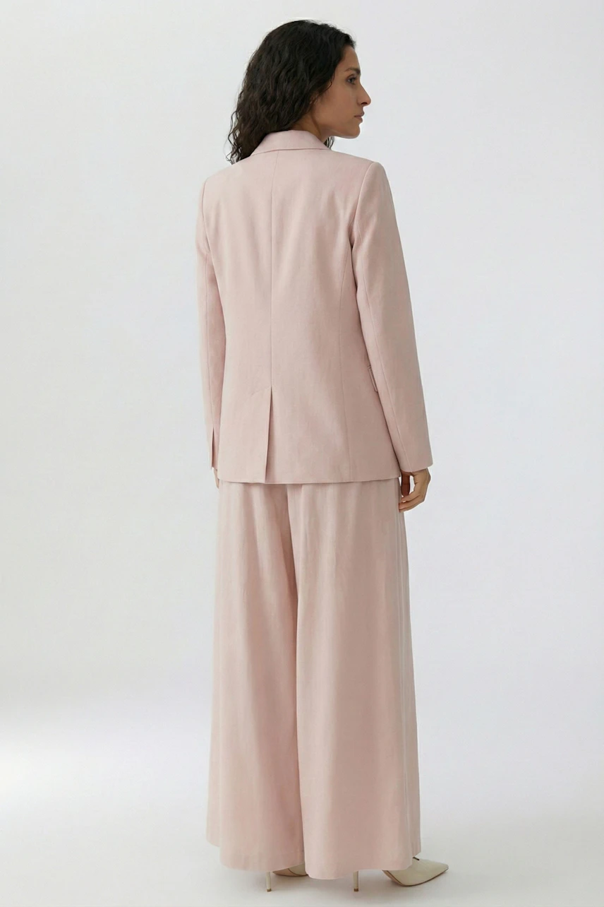 Damen-Blazer in zartem Rosa: Frau trägt einen lässigen Blazer mit schmalem Schnitt und weiten Hosen.