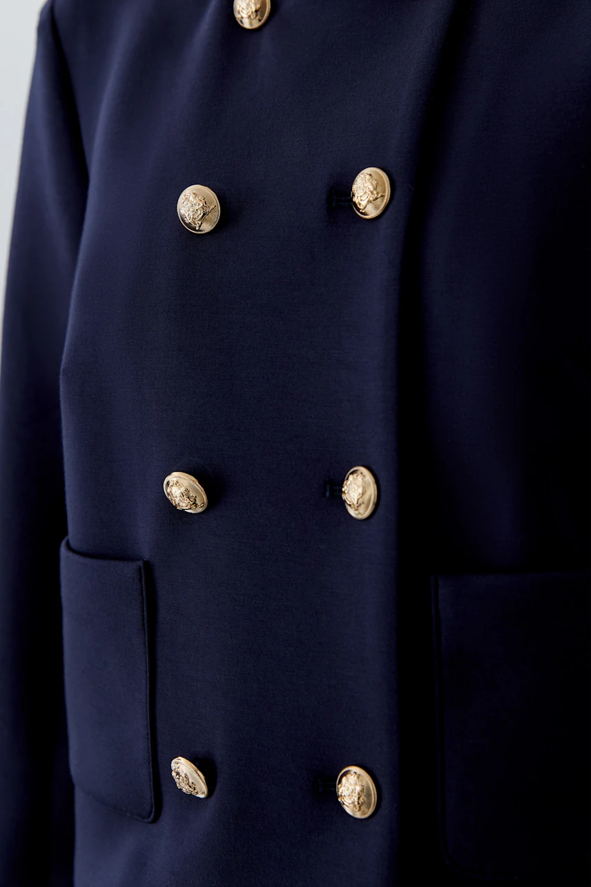 Moderne Damen-Jacke: Dunkelblaue Jacke mit goldenen Knöpfen und praktischen Taschen.
