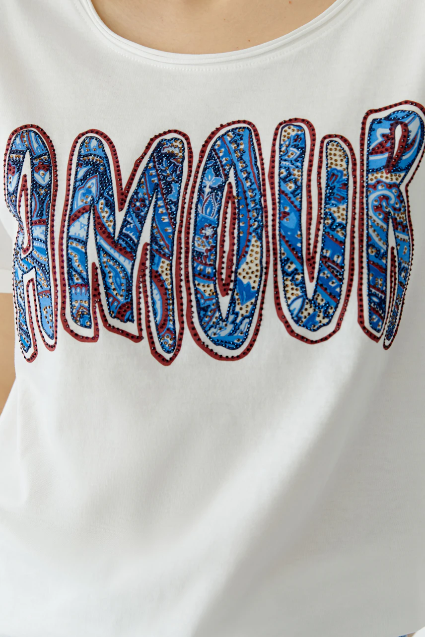Casual women's T-shirt: Close-up of a woman wearing a white tee with colorful 'AMOUR' print.