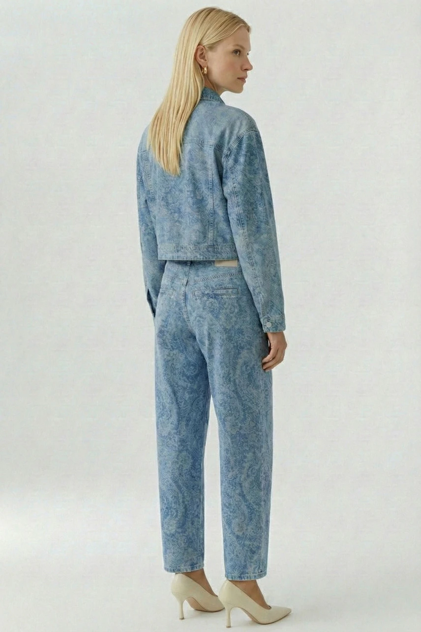 Jeansjacke: Frau in blauer Jeansjacke und passender Hose, seitlich stehend, mit blonden Haaren.