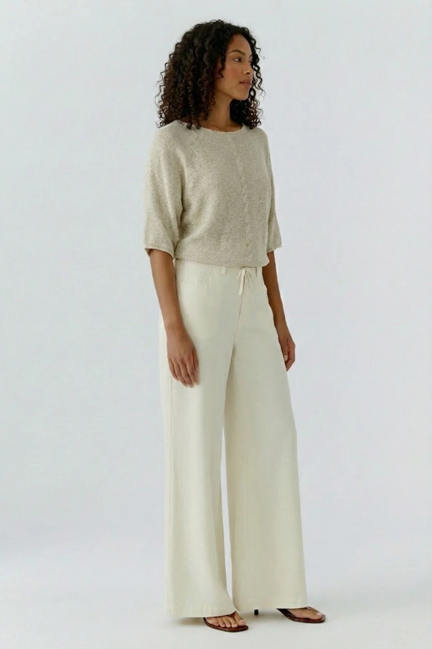 Bequemer Damen-Pullover in hellem Beige, lässig kombiniert mit weiten, hellen Hosen.