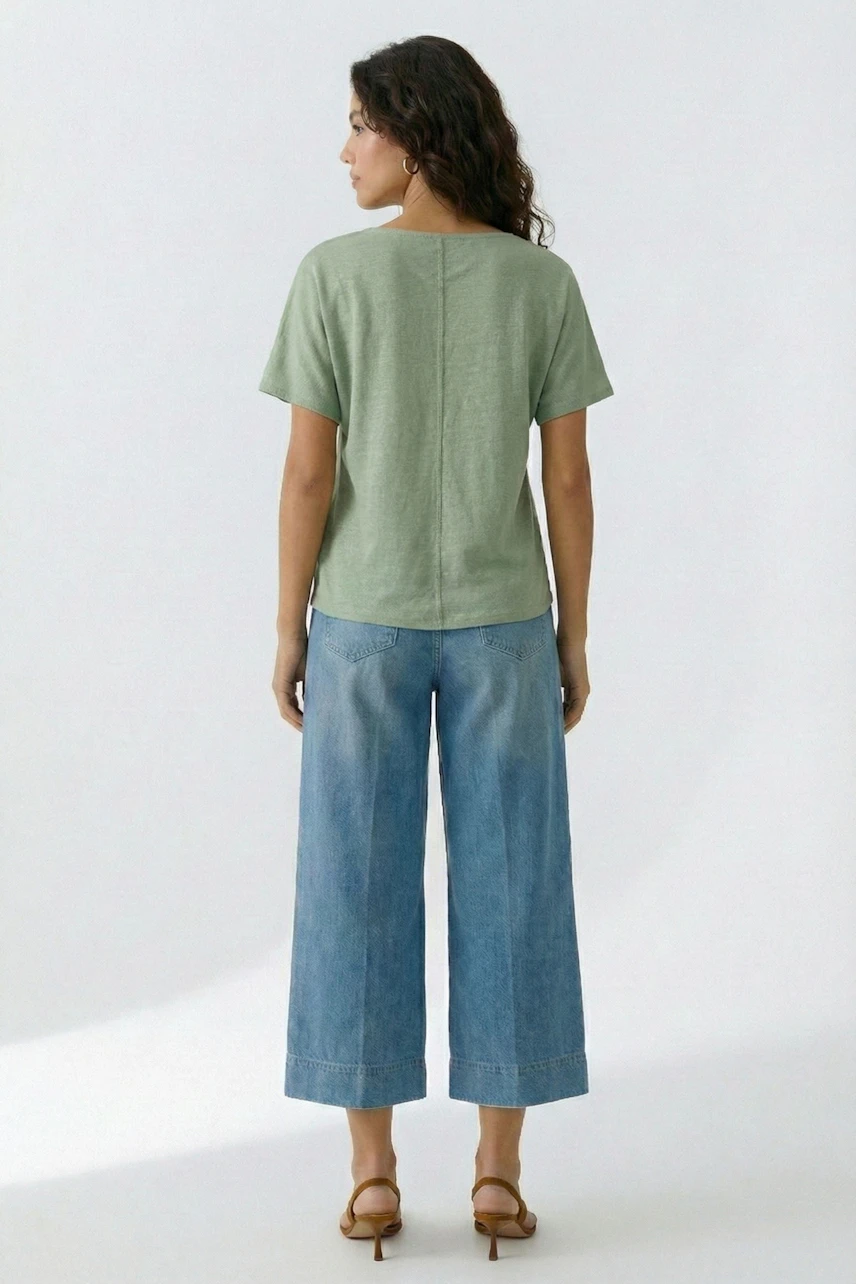 Lässiges Damen-T-Shirt: Frau im grünen T-Shirt und blauen Jeans, von hinten gesehen.