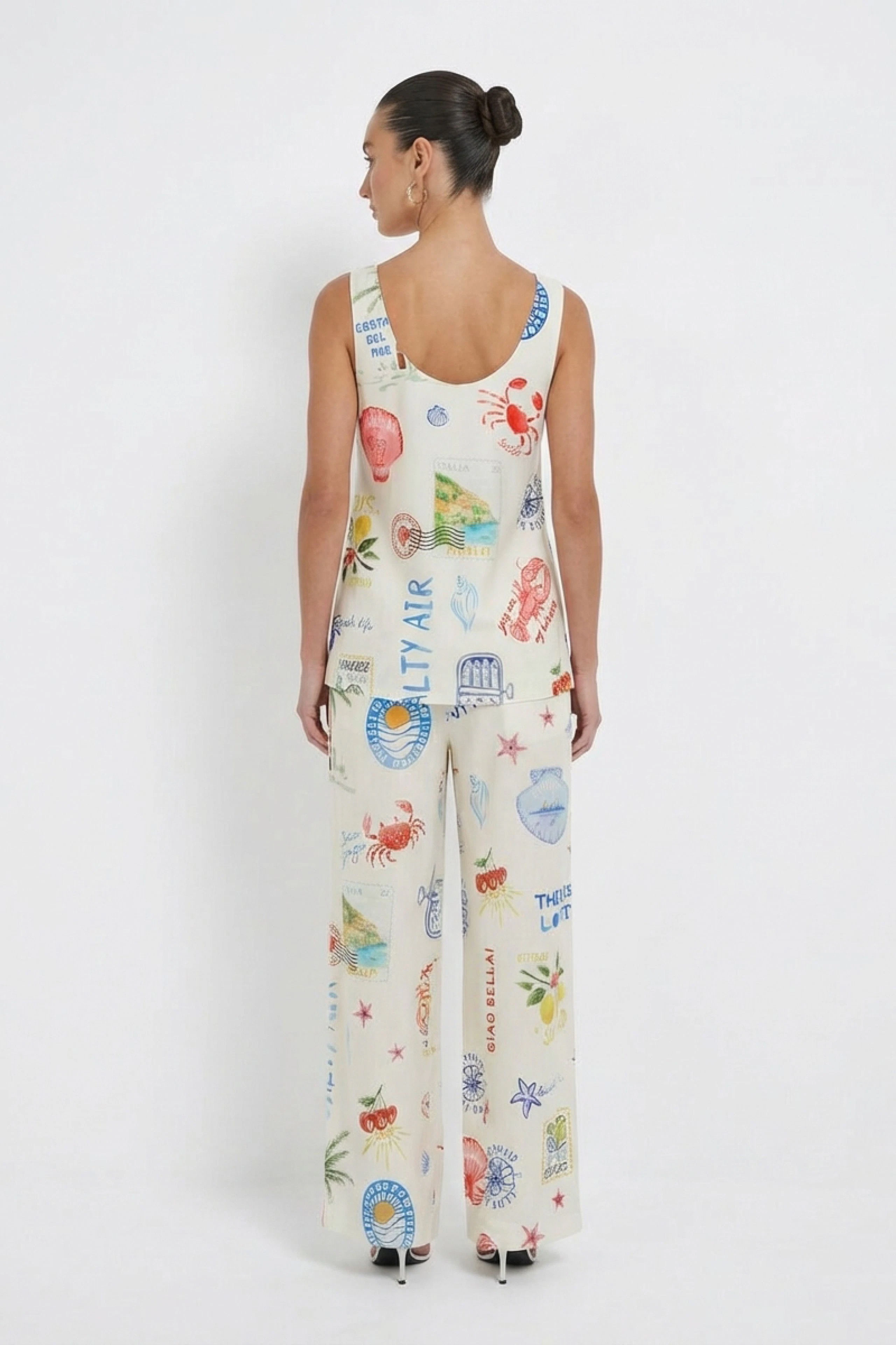 Woman in printed Marlene pants and matching top, showcasing a relaxed, stylish look from behind.