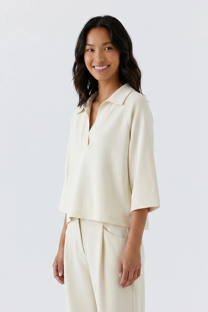 Casual women's sweatshirt: Woman in a cream sweatshirt with relaxed fit and wide sleeves, smiling confidently.