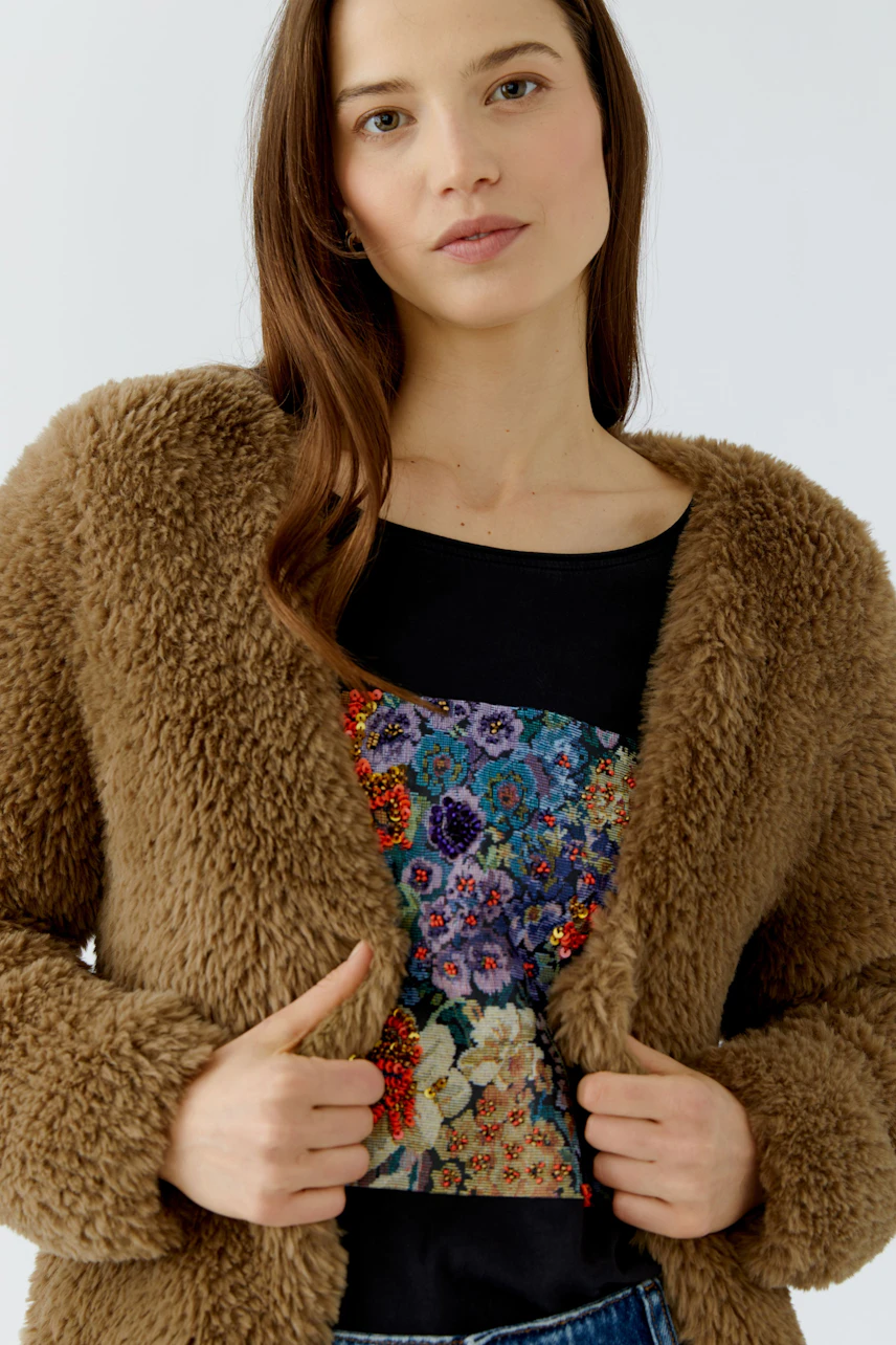 Casual cardigan: Woman in a fluffy brown cardigan over a floral top, exuding a relaxed vibe.