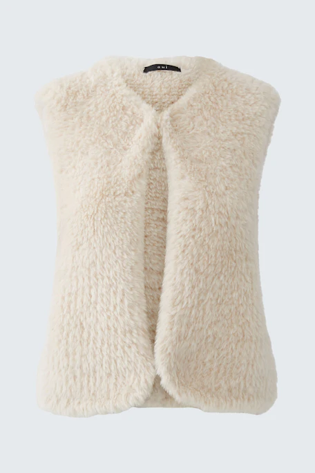 Cozy knit vest: Cream-colored sleeveless vest with soft texture, perfect for layering in cooler weather.