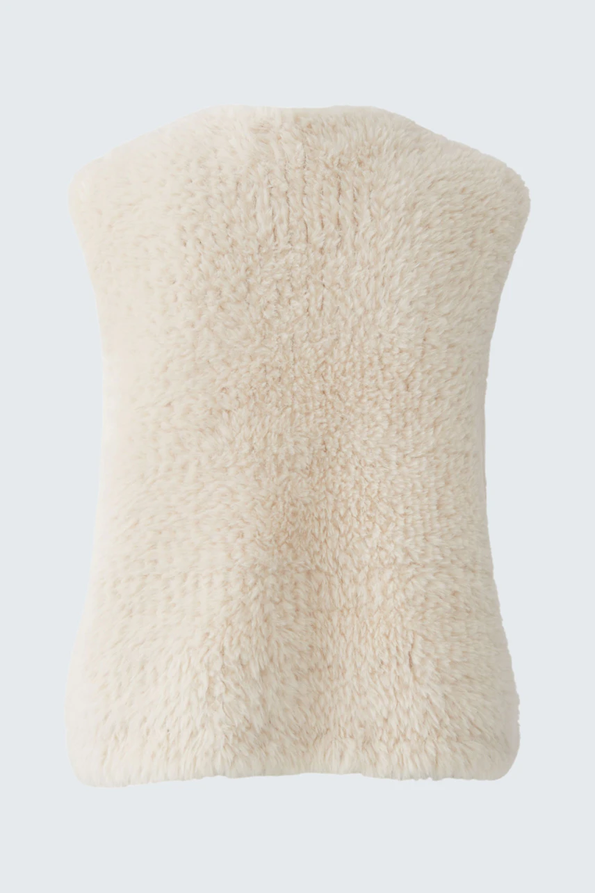 Cozy knit vest in cream color, perfect for layering. Soft texture adds warmth and style to any outfit.