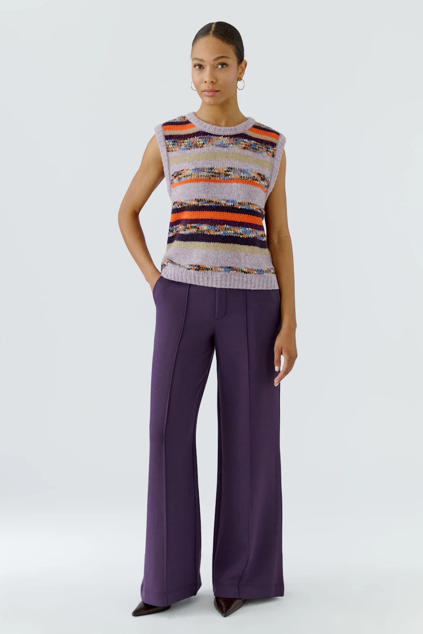 Casual women's pants: Woman in purple wide-leg pants and a colorful sleeveless top stands confidently.
