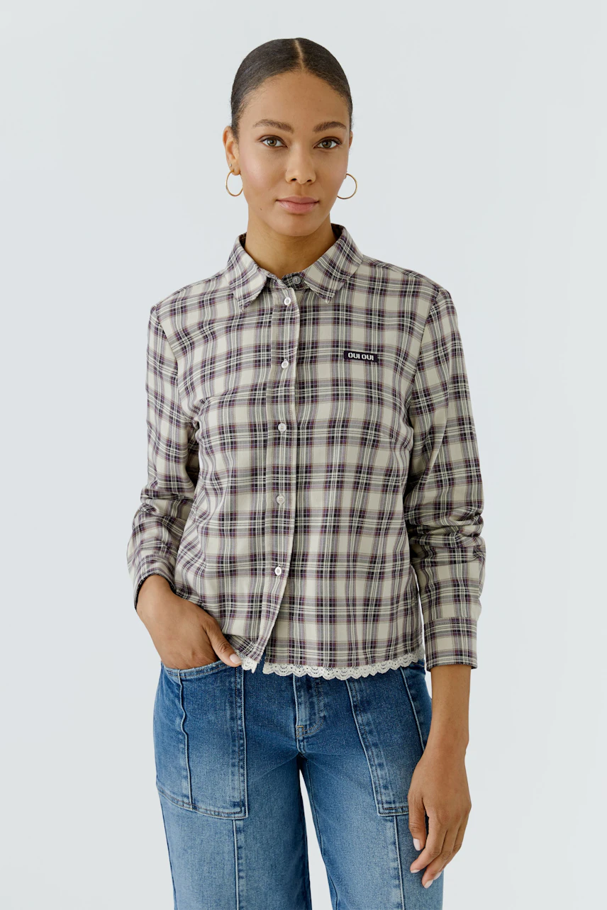 Kariertes Damen-Hemdbluse: Frau in lässiger Bluse mit Jeans, schaut freundlich.