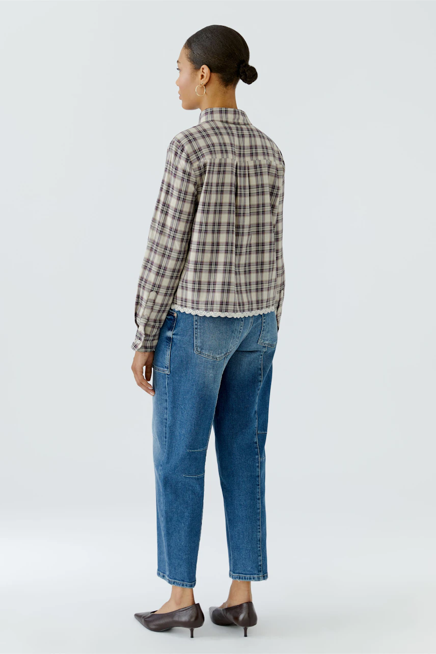 Kariertes Hemdbluse: Frau von hinten in karierter Bluse und blauen Jeans, schlicht und alltagstauglich.