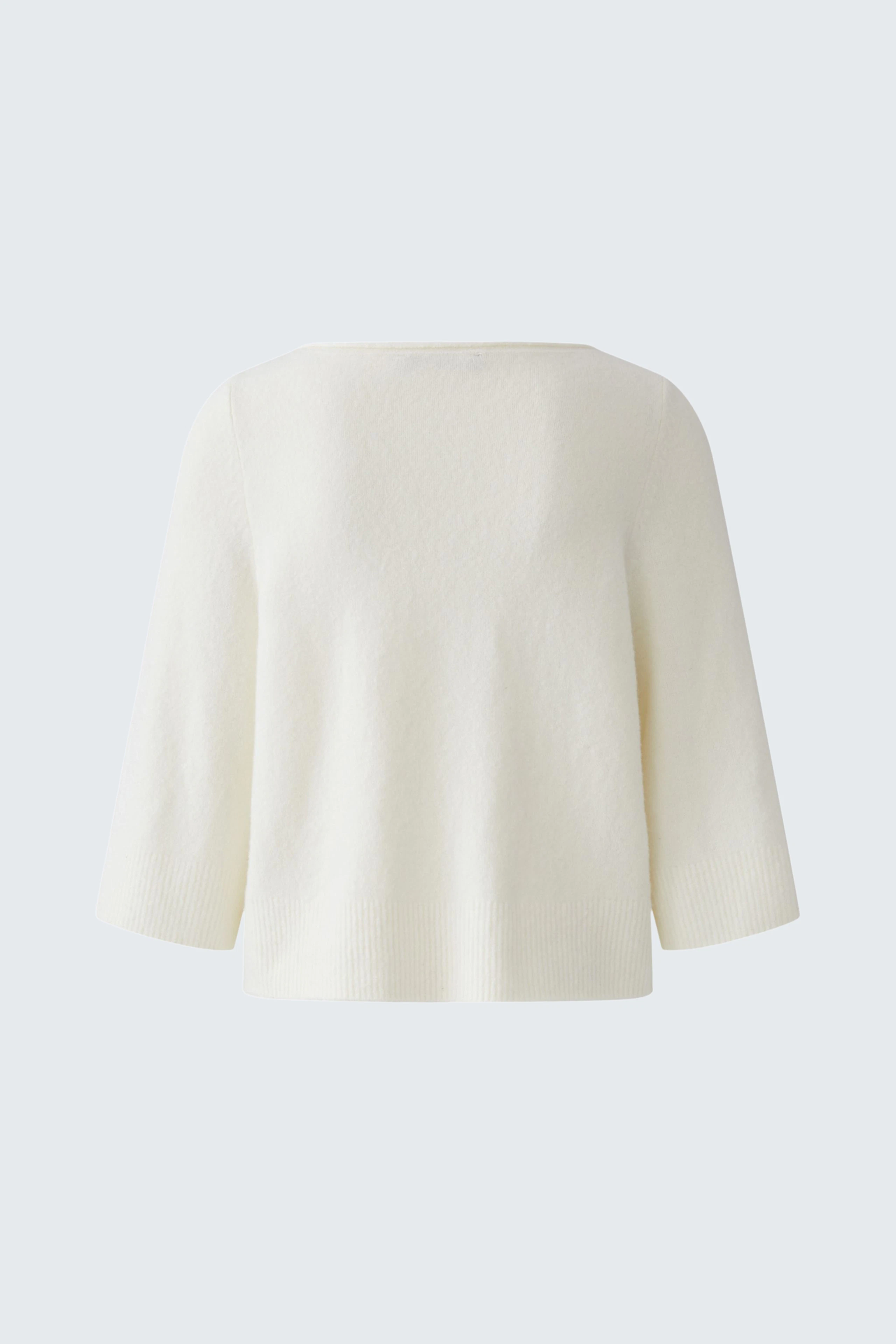 Simple white pullover with wide sleeves, displayed on a plain background.
