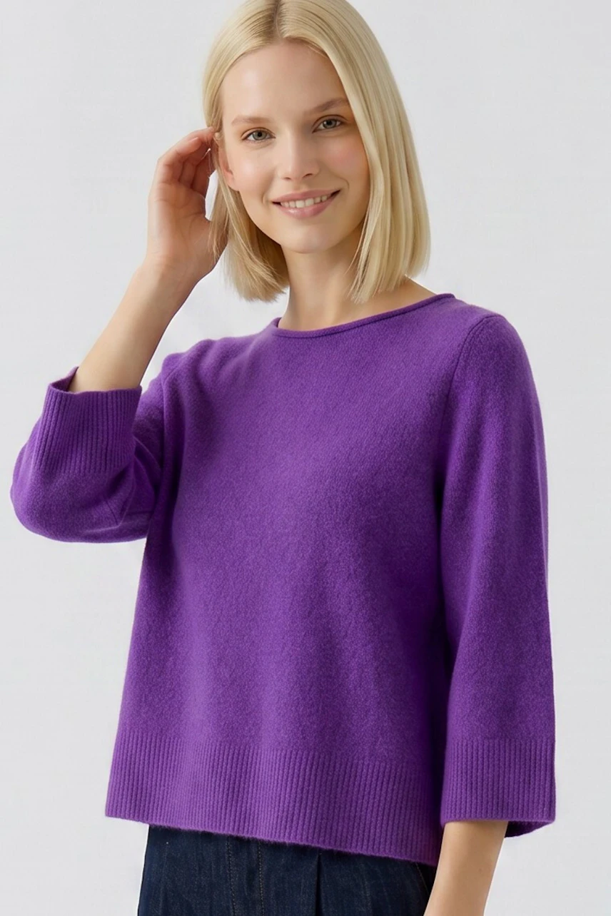 Lila Damen-Pullover: Frau im lässigen Pullover mit 3/4-Ärmeln, kombiniert mit dunkler Jeans.