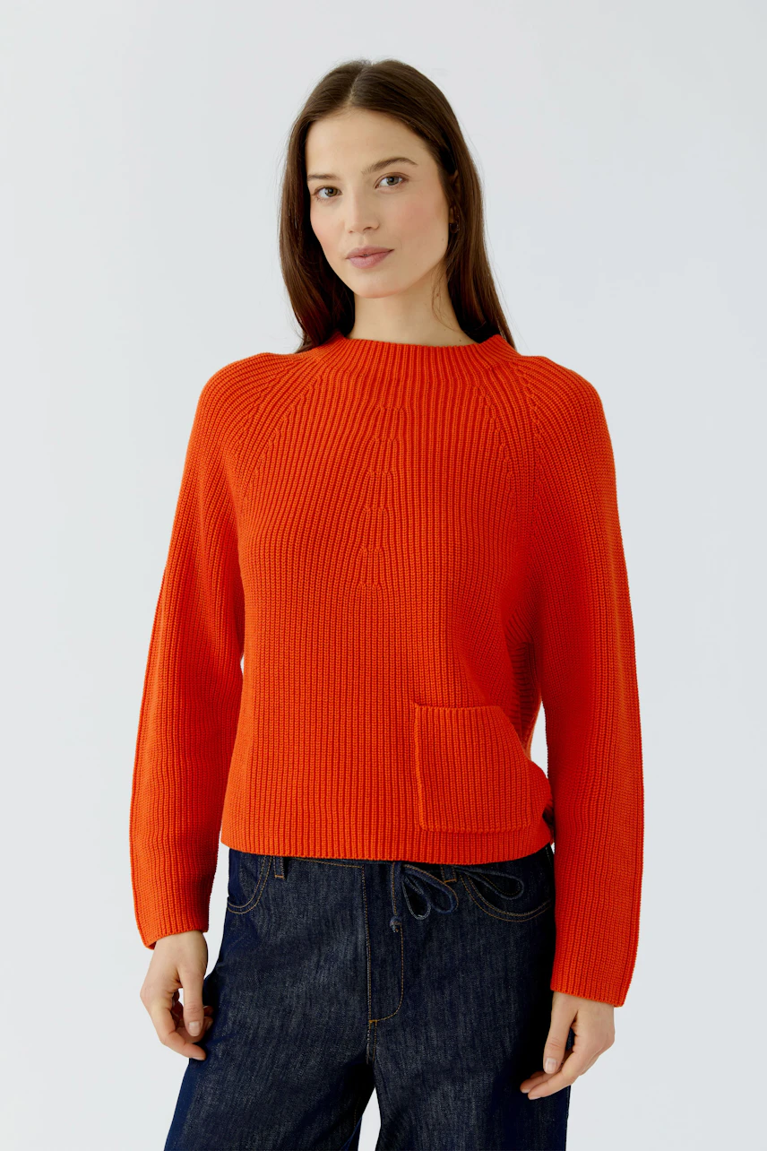 Frau im roten Pullover: Lässiger Strickpullover mit Rundhalsausschnitt und aufgesetzter Tasche.
