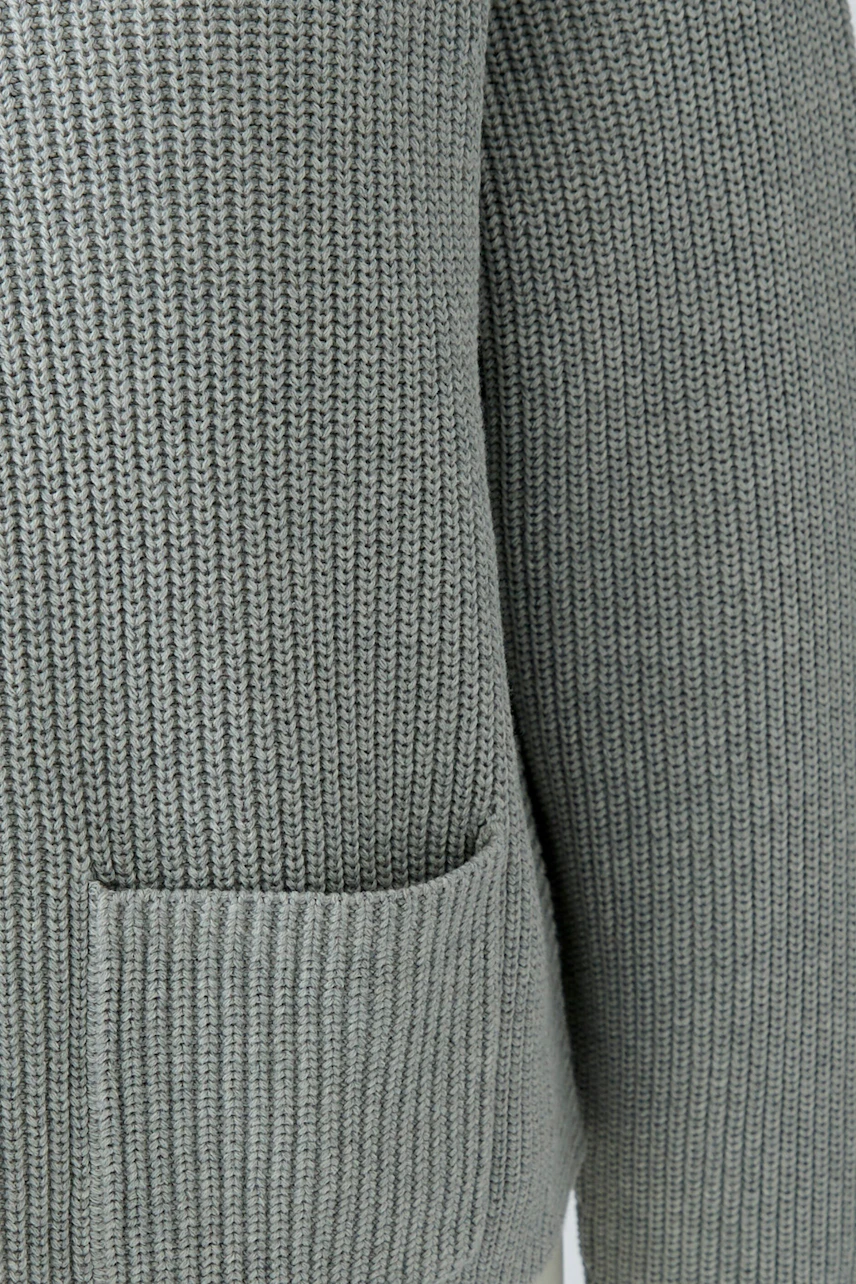 Grauer Damen-Pullover: Detailaufnahme des Strickmusters mit Tasche, ideal für lässige Outfits.