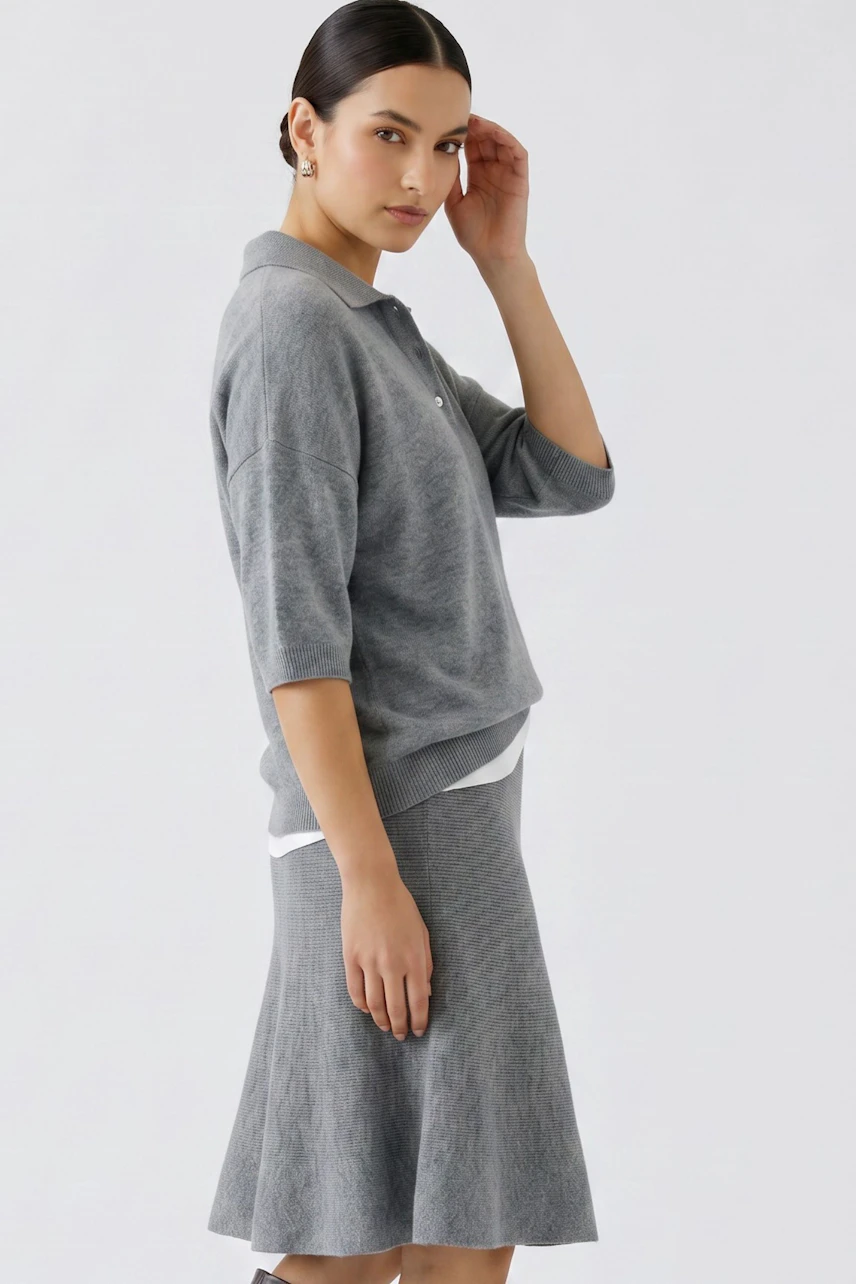 Casual women's pullover: Woman in a grey pullover with a relaxed fit, paired with a matching skirt.