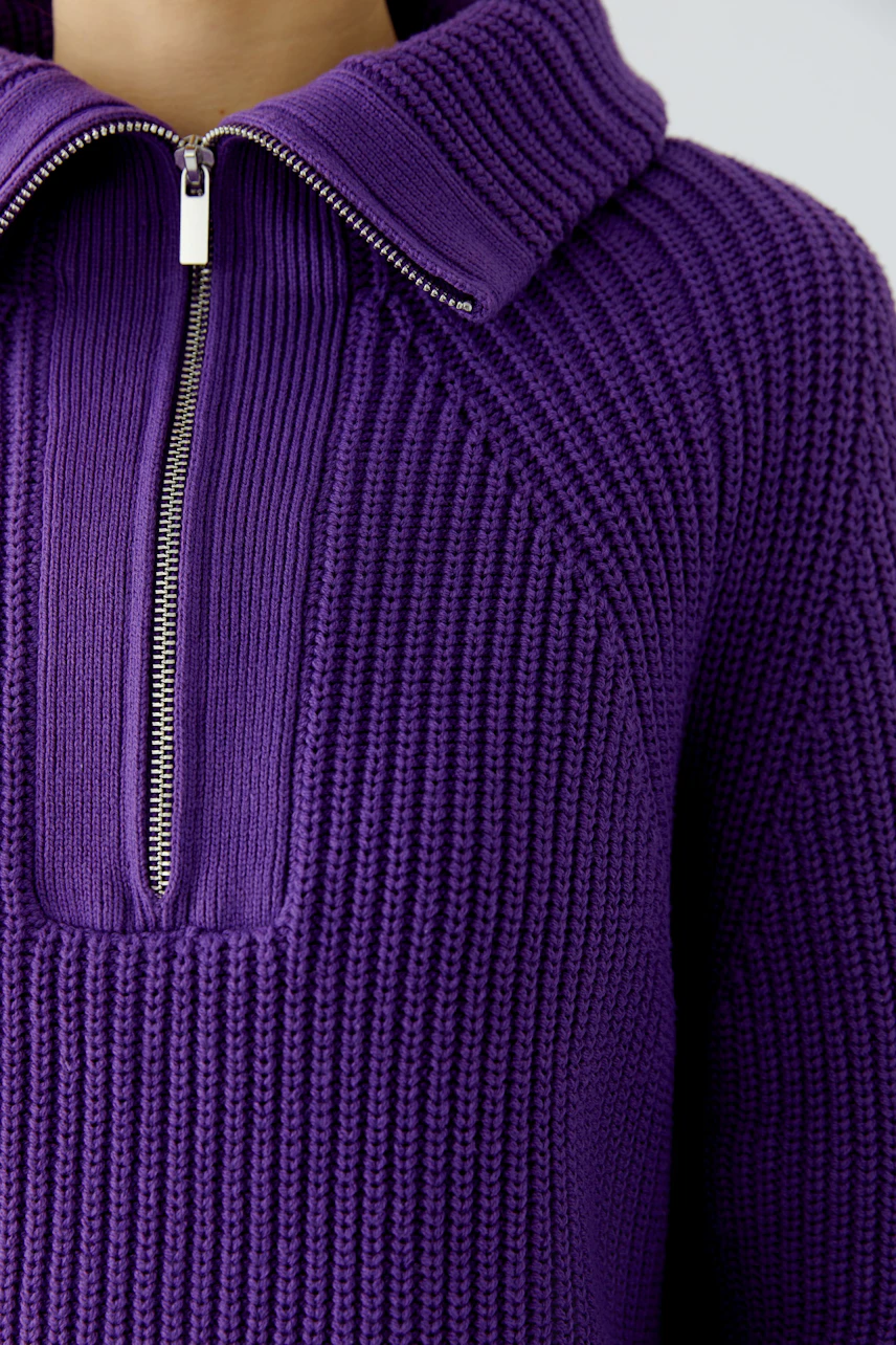 Purple ribbed pullover with zip collar, showcasing texture and style.