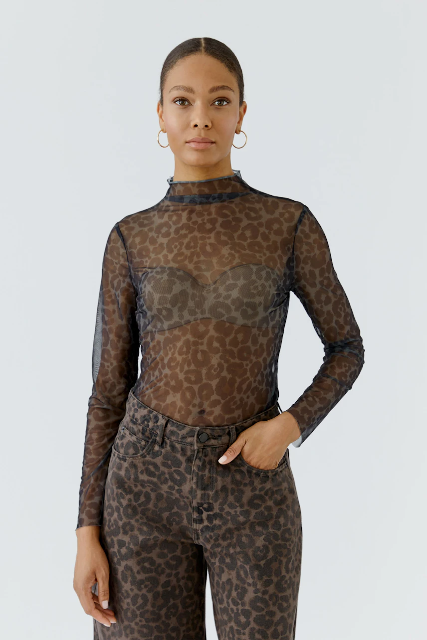 Langarmshirt: Frau im transparenten, gemusterten Langarmshirt mit Leopardenmuster und passender Hose.
