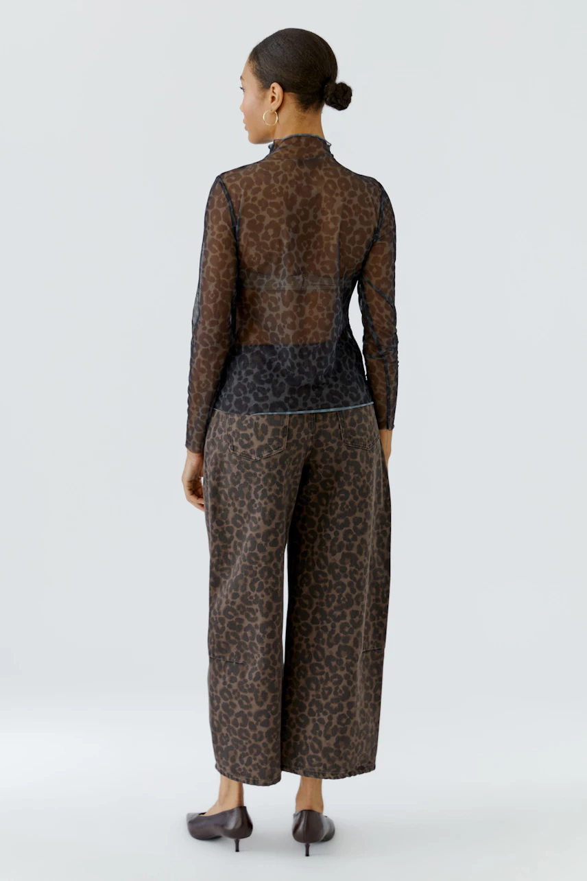 Langarmshirt mit Leopardenmuster: Frau von hinten im transparenten Shirt und passender Hose.