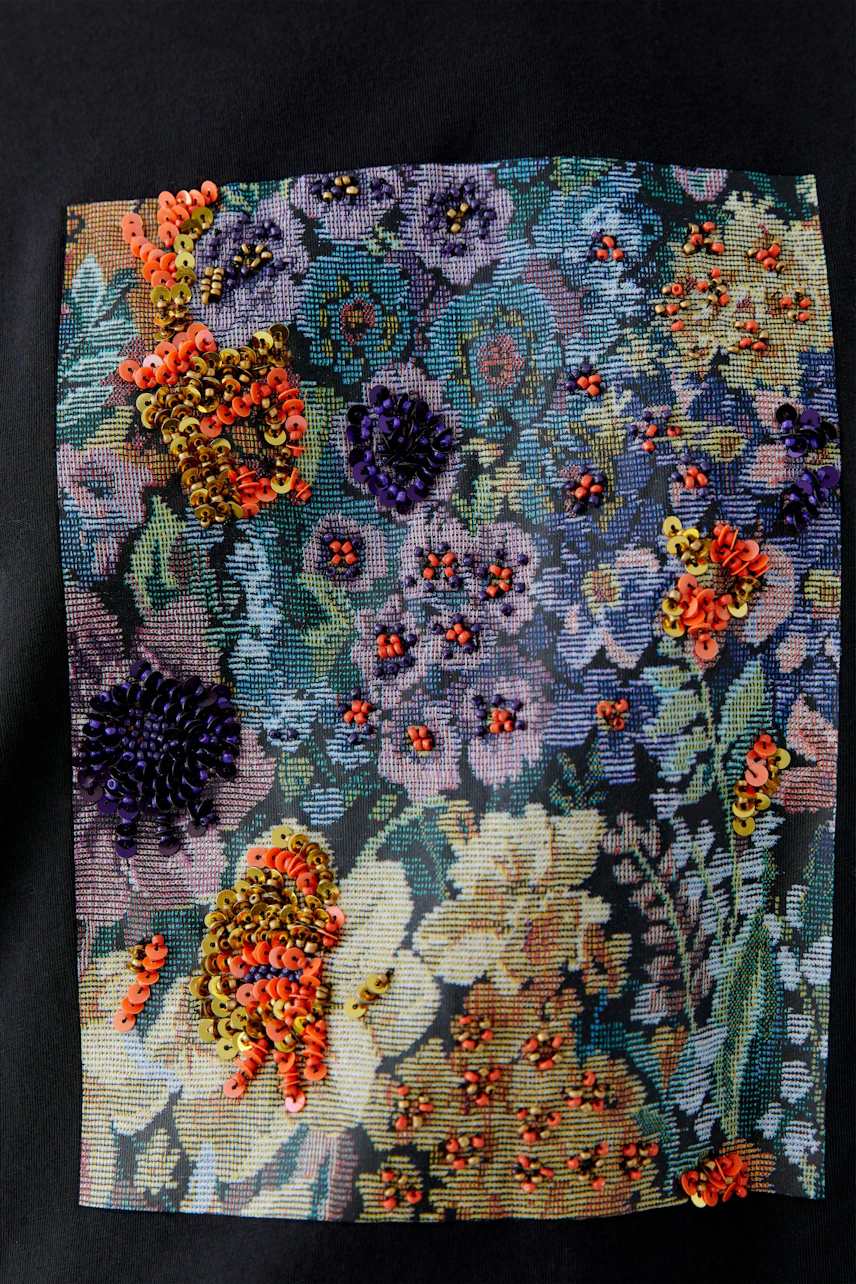 Floral T-shirt: Close-up of colorful embroidered flowers on fabric, showcasing vibrant design details.