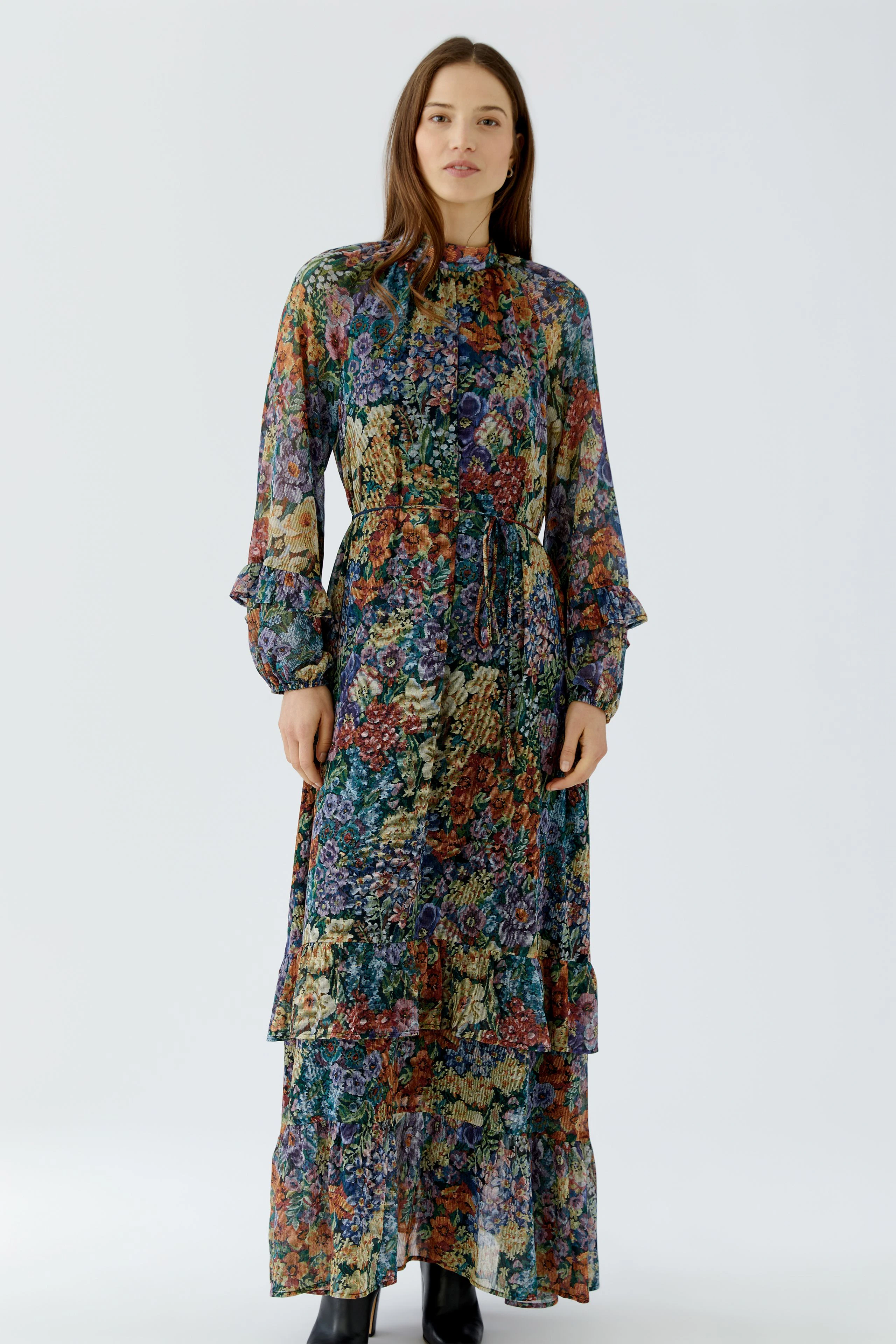Frau im floralen Maxikleid: Langes, buntes Kleid mit Blumenmuster und Rüschenärmeln, lässig und stilvoll.