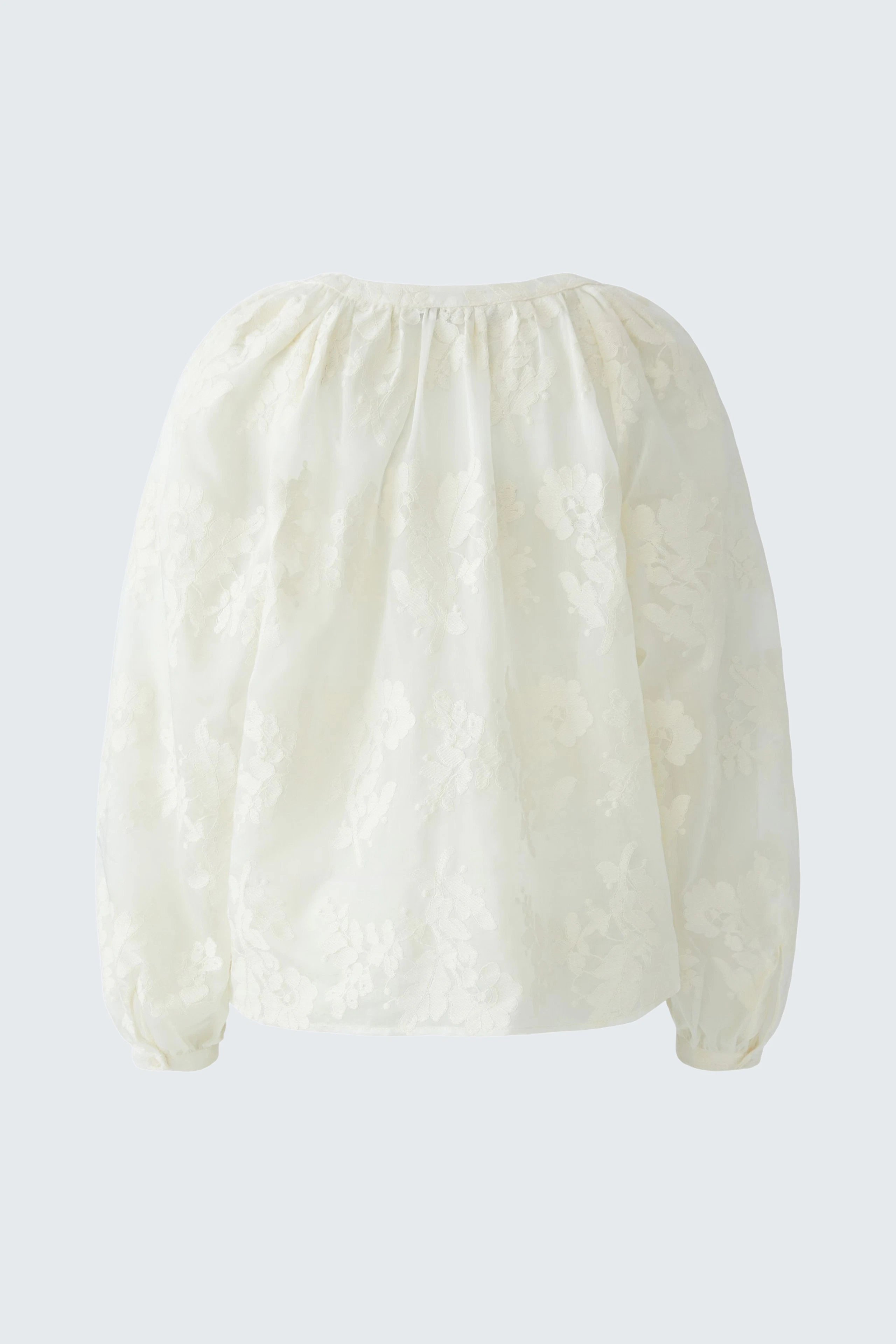 White tunic with floral texture, loose fit, and long sleeves. No model, just the garment displayed.