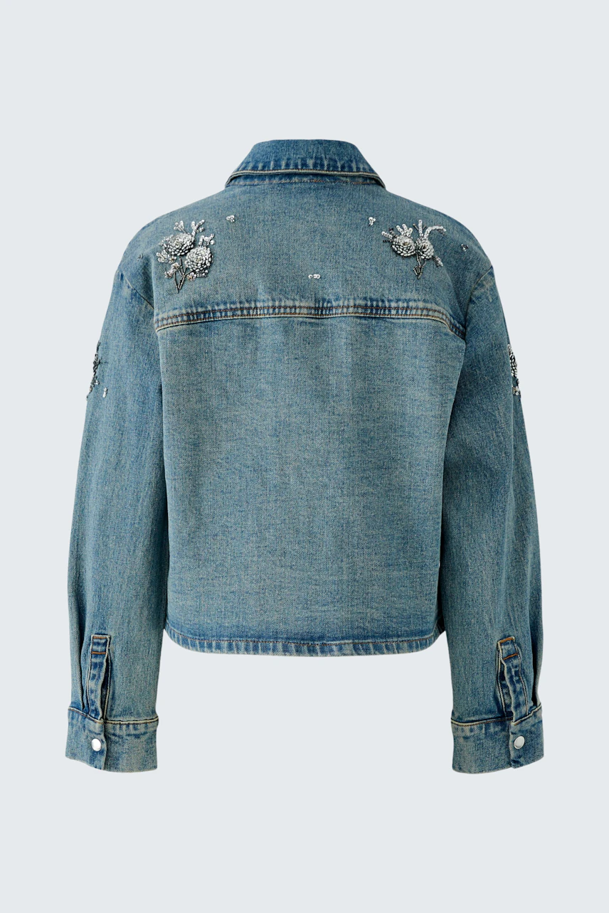 Denim jacket with floral embroidery on back, showcasing casual style. No model present.
