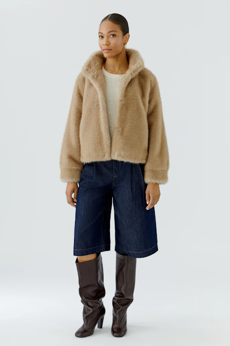 Cozy outdoor jacket: Soft, tan faux fur jacket with high collar, perfect for chilly days.