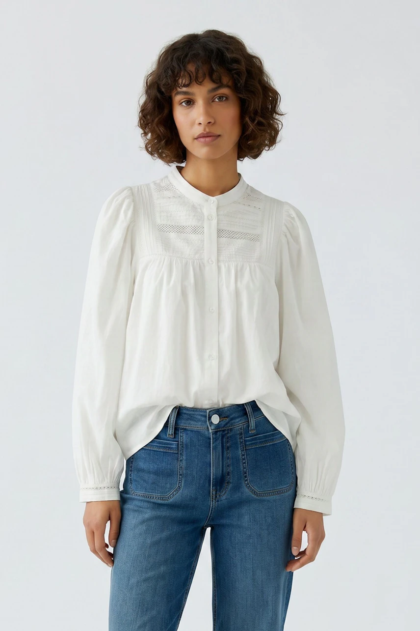 Weiße Damen-Bluse: Frau in lockerer Bluse mit Spitzen-Details und blauen Jeans, lässig und modern.