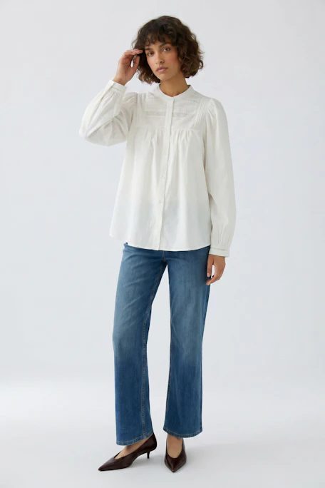Weiße Damen-Bluse mit Knopfleiste und dezenten Details, ohne Model präsentiert.