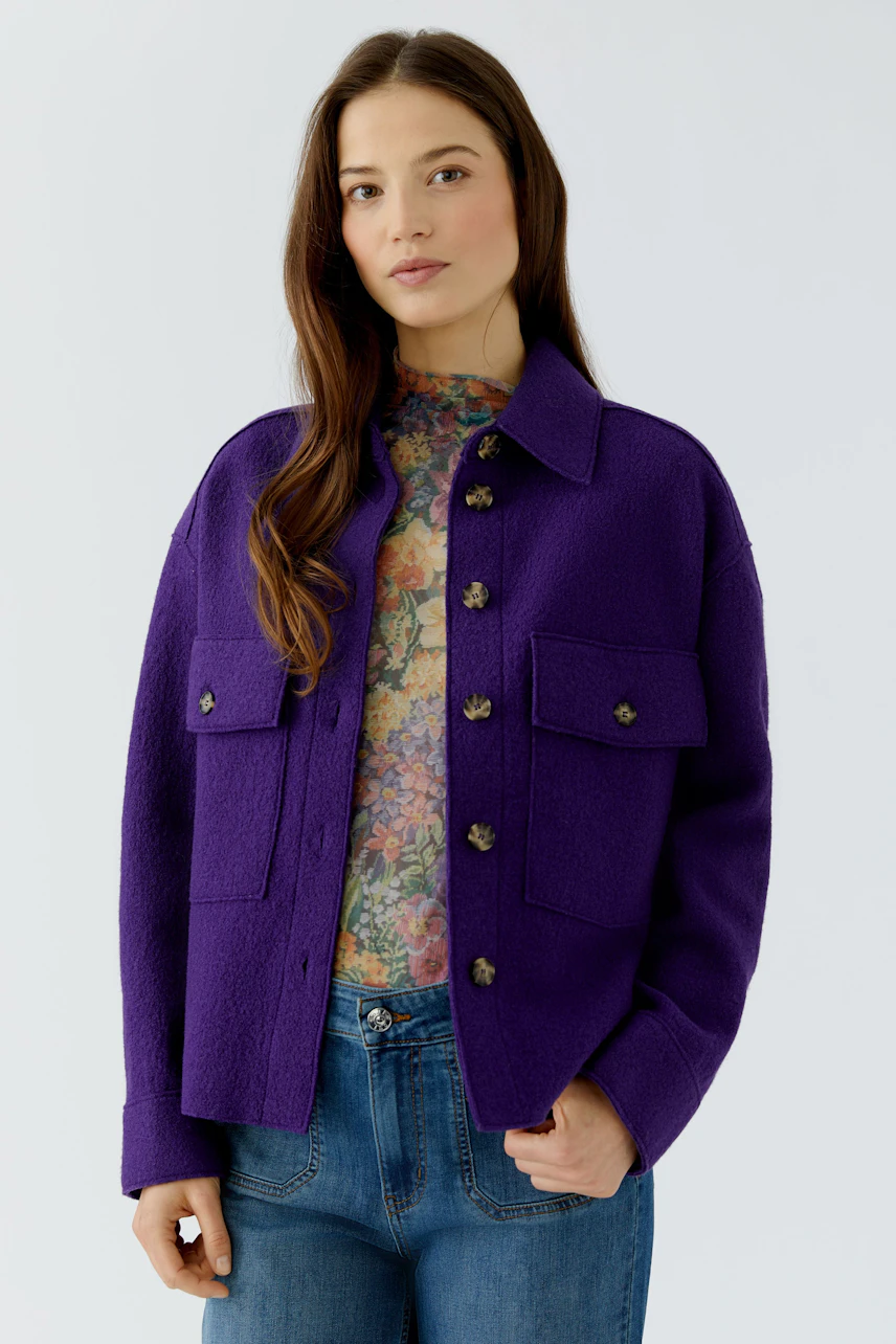 Casual overshirt: Woman in a purple overshirt with floral top and jeans, exuding a relaxed vibe.