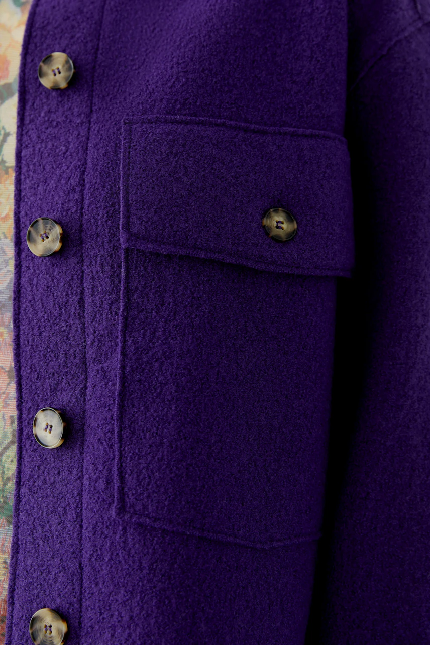 Purple overshirt with button details and chest pocket, showcasing textured fabric.