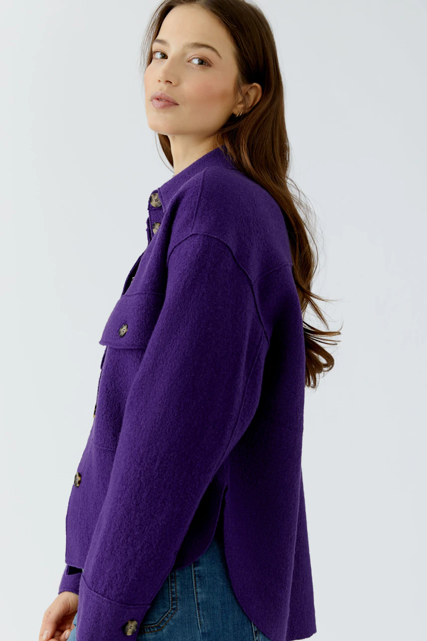 Casual women's overshirt: Woman in a purple overshirt with button details, paired with blue jeans.