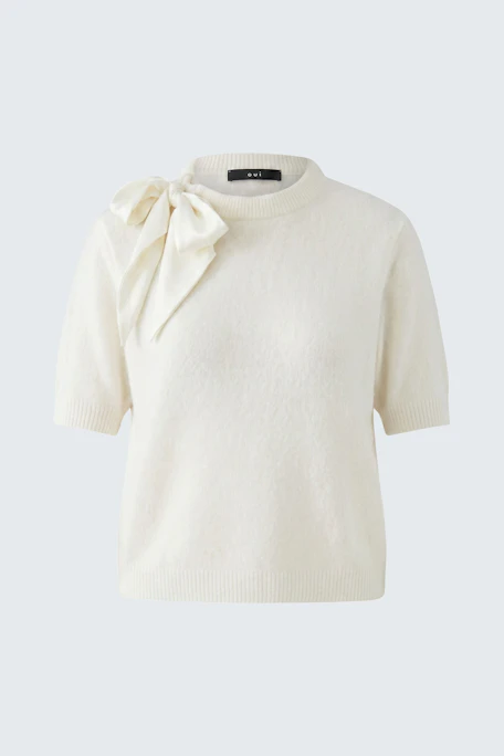 White pullover with short sleeves and a large bow on the shoulder.