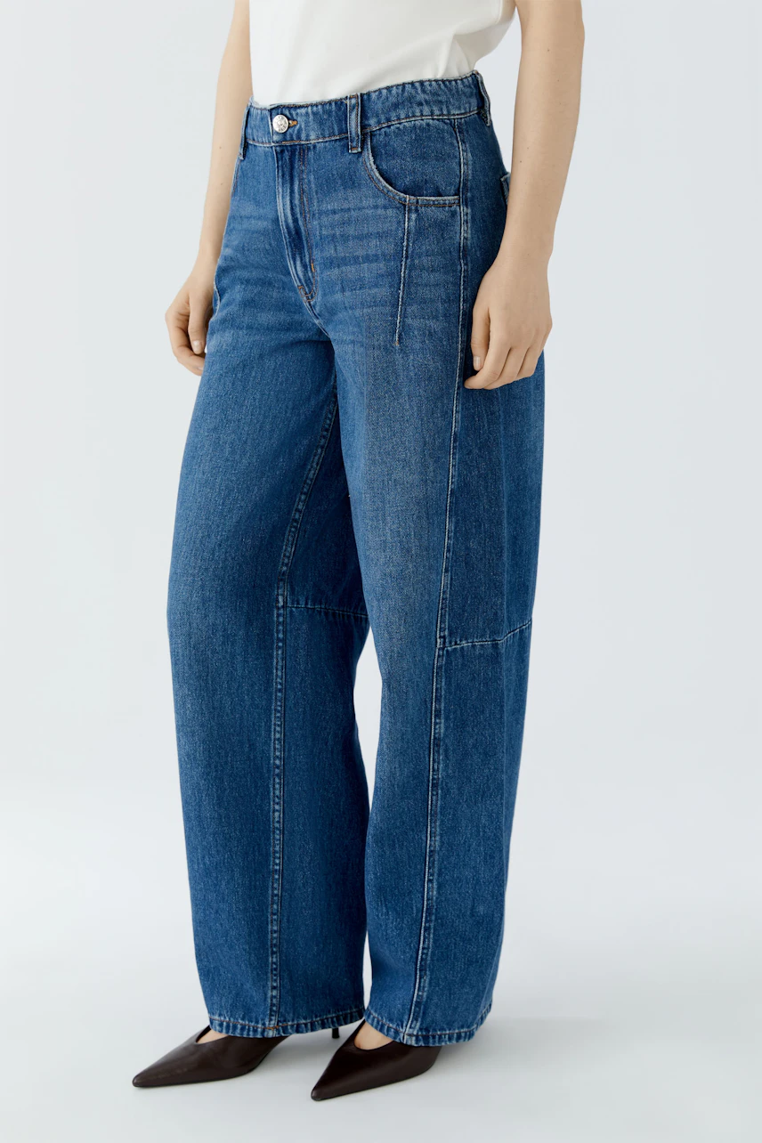 Frau in blauer Jeans Barrel: Weit geschnittene Hose, hoher Bund, lässiger Look.