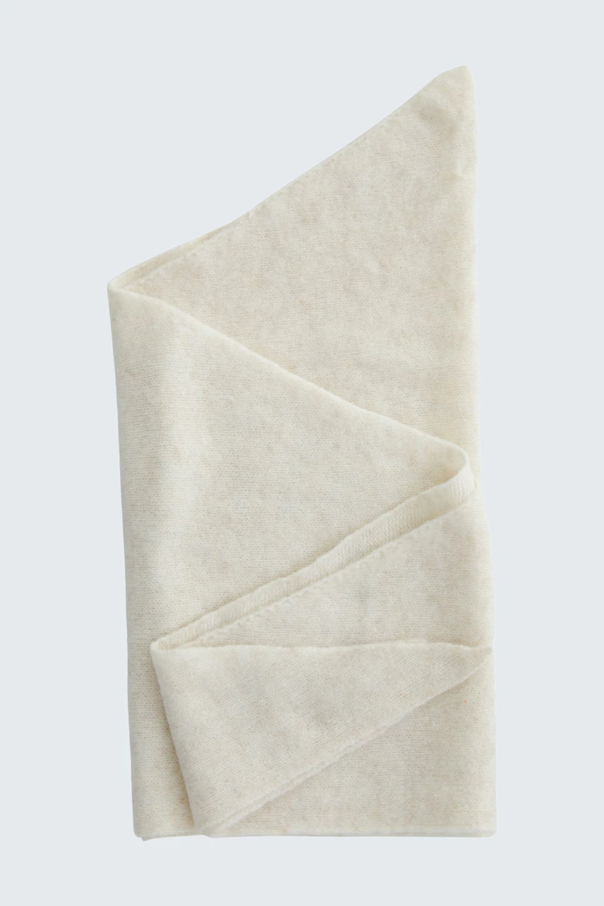 Soft beige scarf folded neatly, showcasing its texture and simplicity. Ideal for versatile styling.