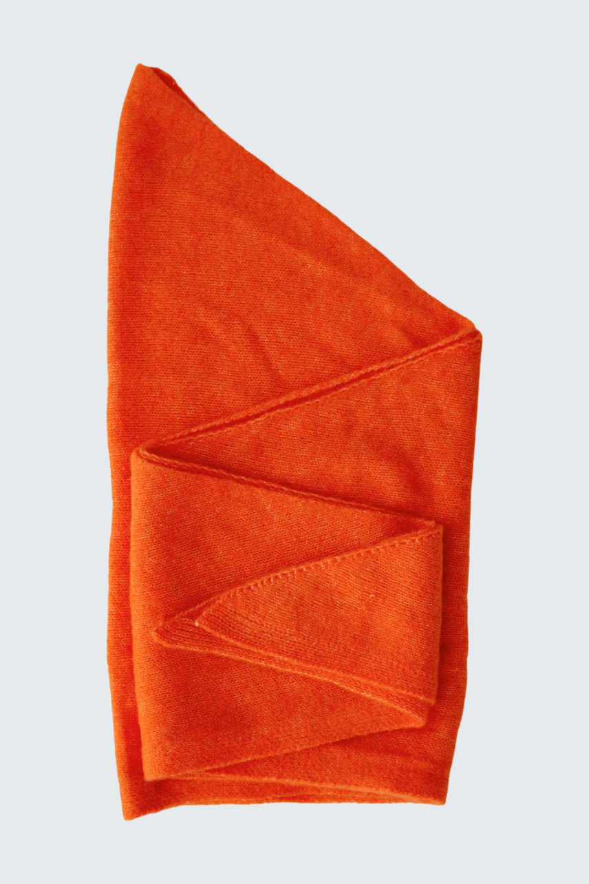 Bright orange scarf folded neatly, showcasing its vibrant color and soft texture.
