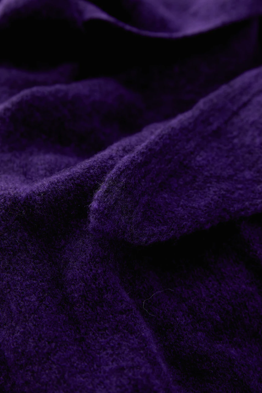 Soft purple scarf with textured fabric, perfect for adding warmth and style to any outfit.