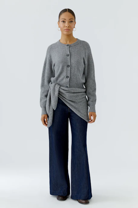 Grauer Schal aus weichem Stoff, ideal für kühle Tage. Zeitloses Accessoire für vielseitige Looks.