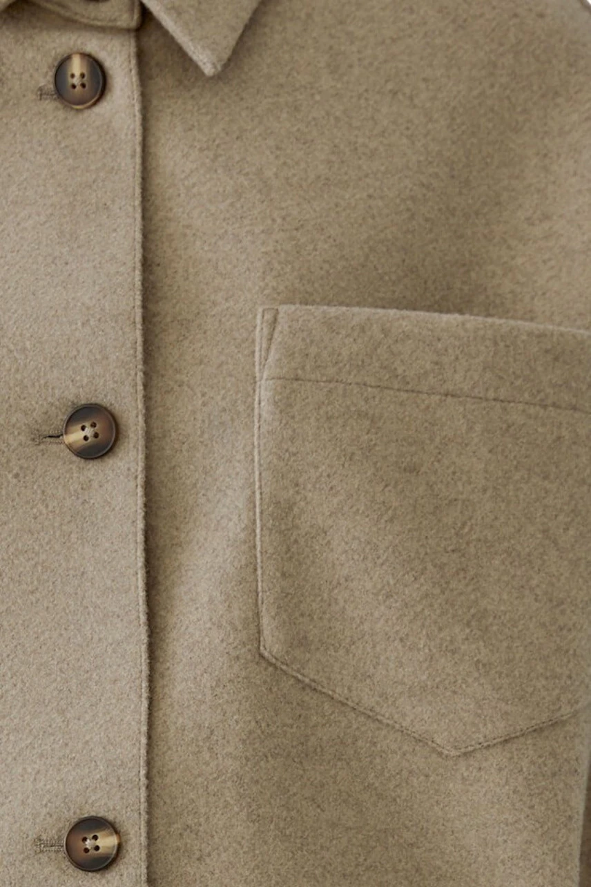 Beige Jacke mit Knopfleiste und Brusttasche, aus weichem Stoff. Ideal für lässige Outfits.