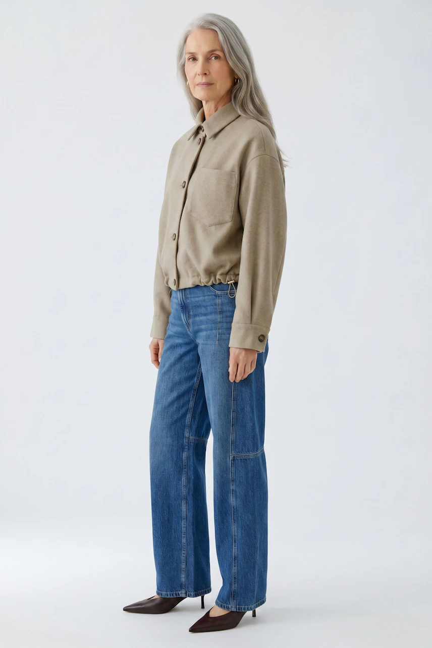 Casual women's jacket: Woman in beige jacket with button details, paired with blue jeans, standing confidently.
