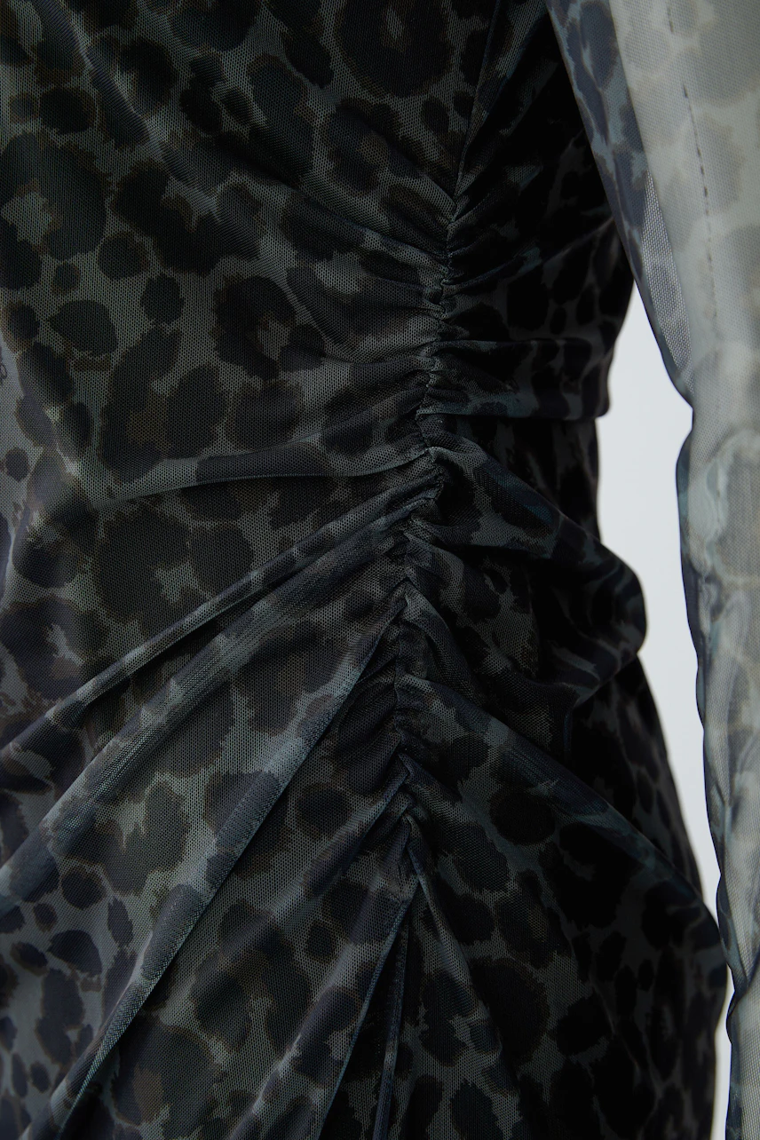 Leopard print midi dress with ruched details, showcasing a bold and stylish design.
