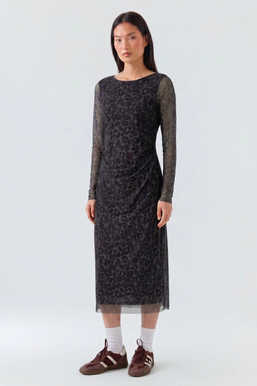 Casual midi dress: Woman in a patterned long-sleeve midi dress with sneakers, standing confidently.
