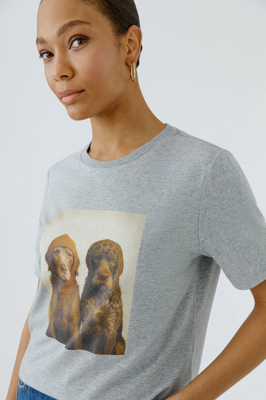 Graues Damen-T-Shirt: Frau trägt T-Shirt mit Hundeprint, lässiger Look.