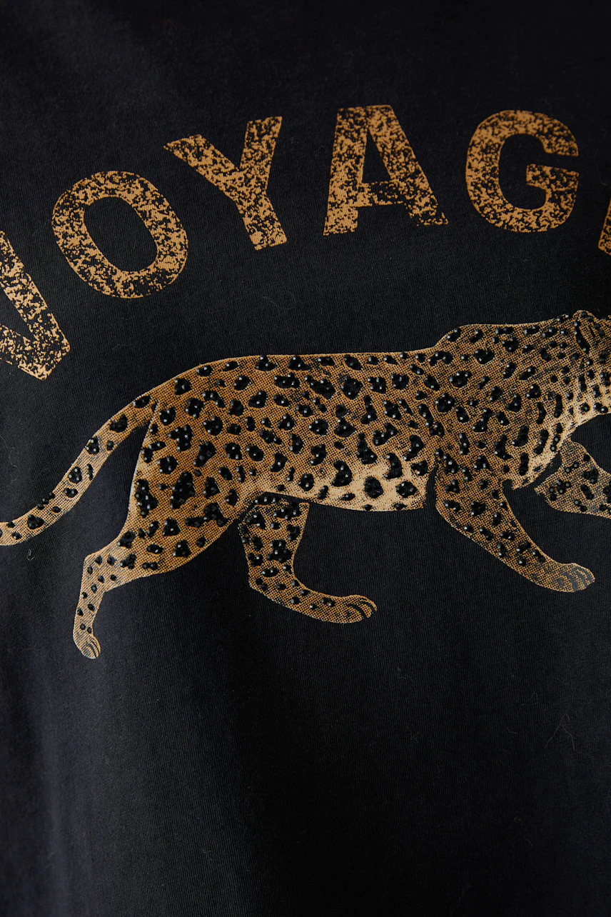 Schwarzes T-Shirt mit Leoparden-Print und Schriftzug "Voyage". Ideal für einen lässigen Look.